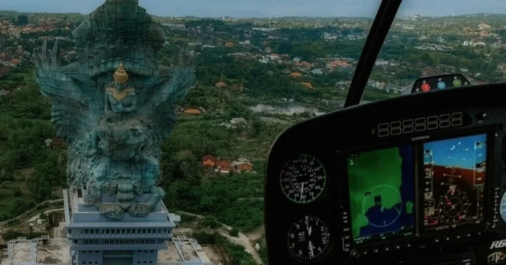 Pemandangan Patung Garuda Wisnu Kencana dan kawasan hijau Bali terlihat dari kokpit helikopter saat penerbangan wisata udara.