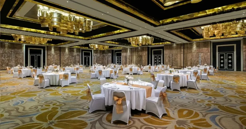 Ballroom luas dengan meja bundar dan kursi tertata untuk resepsi pernikahan di Bali.