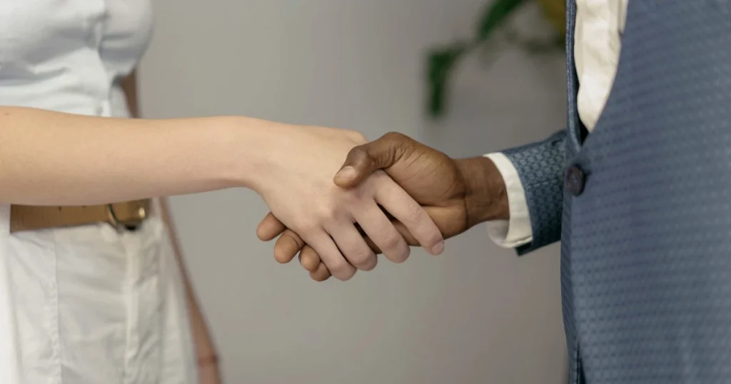 Dua profesional berjabat tangan sebagai simbol kerja sama bisnis dalam kegiatan business matching untuk membangun kemitraan.